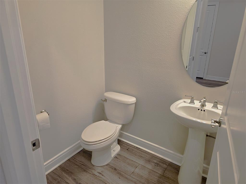 6349 Mossy Oak Road St. Cloud, FL 34771 - Photo 15 of 82 a white toilet sitting next to a bathroom sink