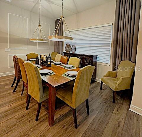 6349 Mossy Oak Road St. Cloud, FL 34771 - Photo 27 of 82 a dining room with furniture a chandelier and wooden floor