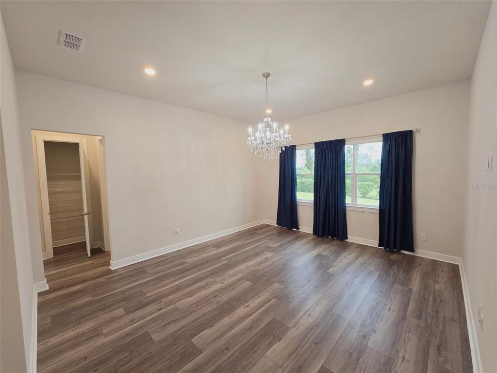 6349 Mossy Oak Road St. Cloud, FL 34771 - Photo 36 of 82 a view of an empty room with wooden floor and a window