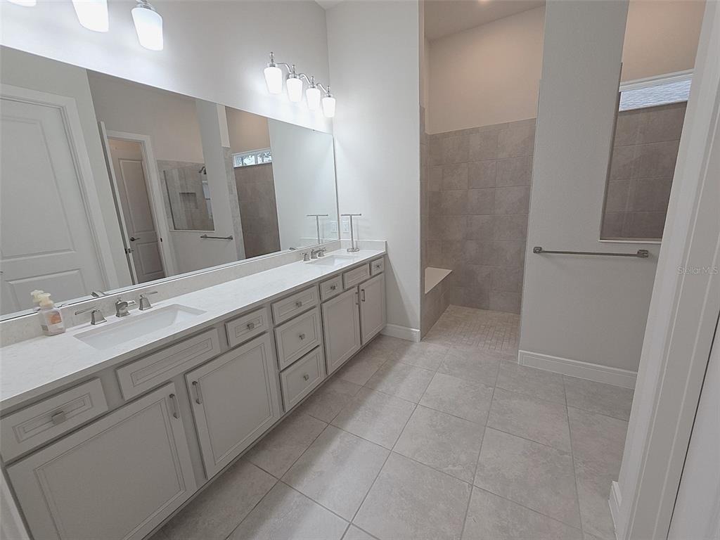 6349 Mossy Oak Road St. Cloud, FL 34771 - Photo 46 of 82 a spacious bathroom with a double vanity sink a toilet and a mirror