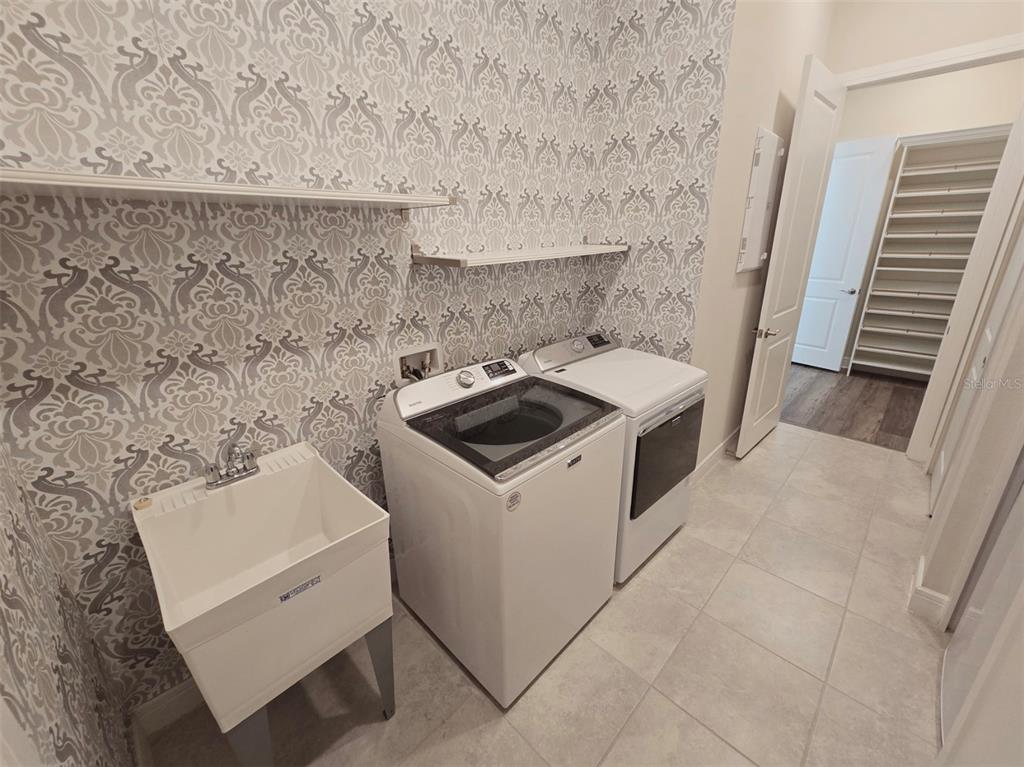 6349 Mossy Oak Road St. Cloud, FL 34771 - Photo 53 of 82 a utility room with a sink dryer and washer