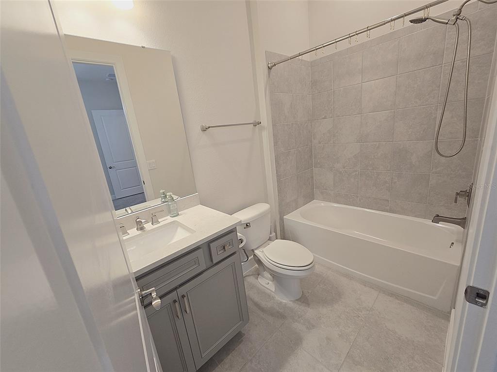 6349 Mossy Oak Road St. Cloud, FL 34771 - Photo 59 of 82 a bathroom with a sink toilet vanity and shower