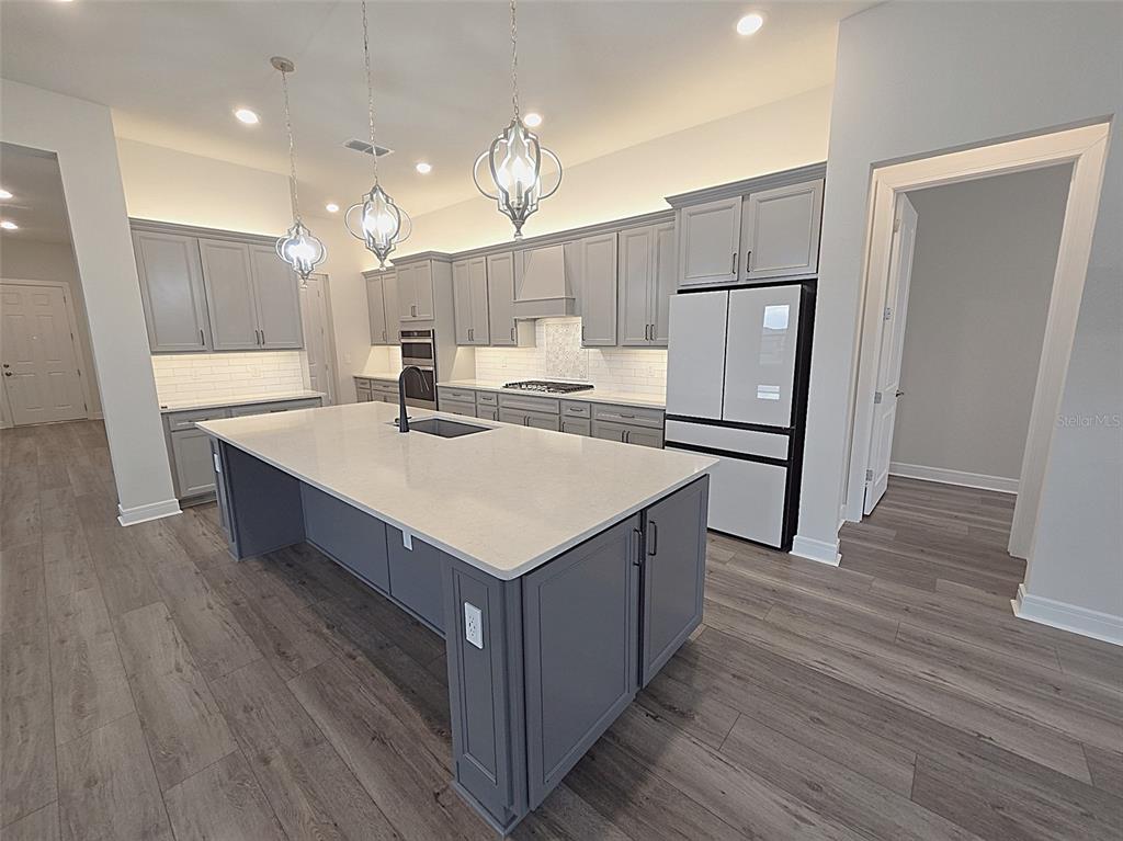6349 Mossy Oak Road St. Cloud, FL 34771 - Photo 8 of 82 a kitchen with a refrigerator a sink and a microwave