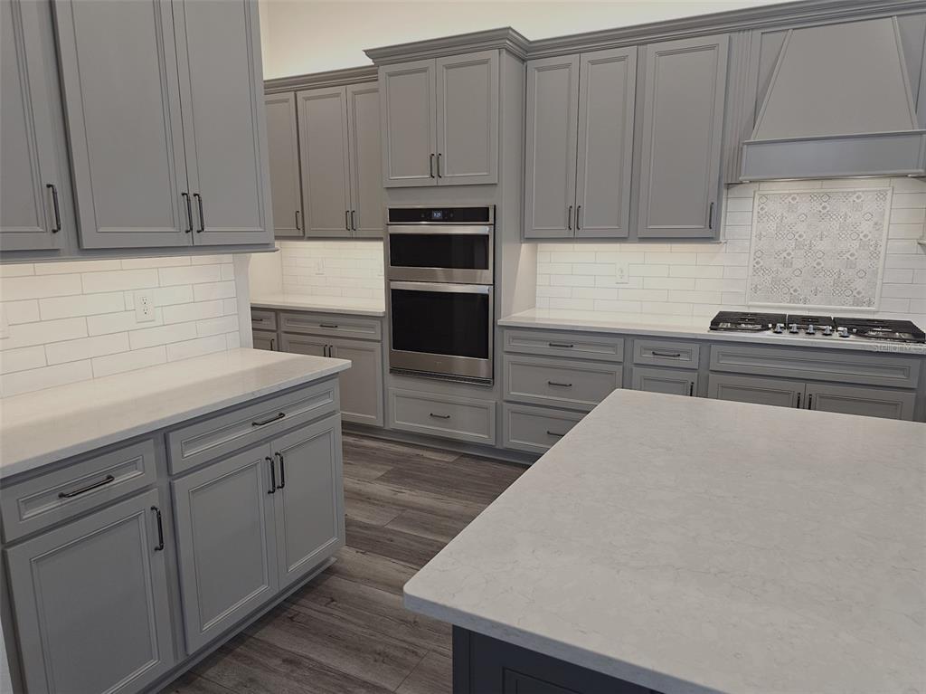 6349 Mossy Oak Road St. Cloud, FL 34771 - Photo 10 of 82 a kitchen with stainless steel appliances a stove a microwave and cabinets