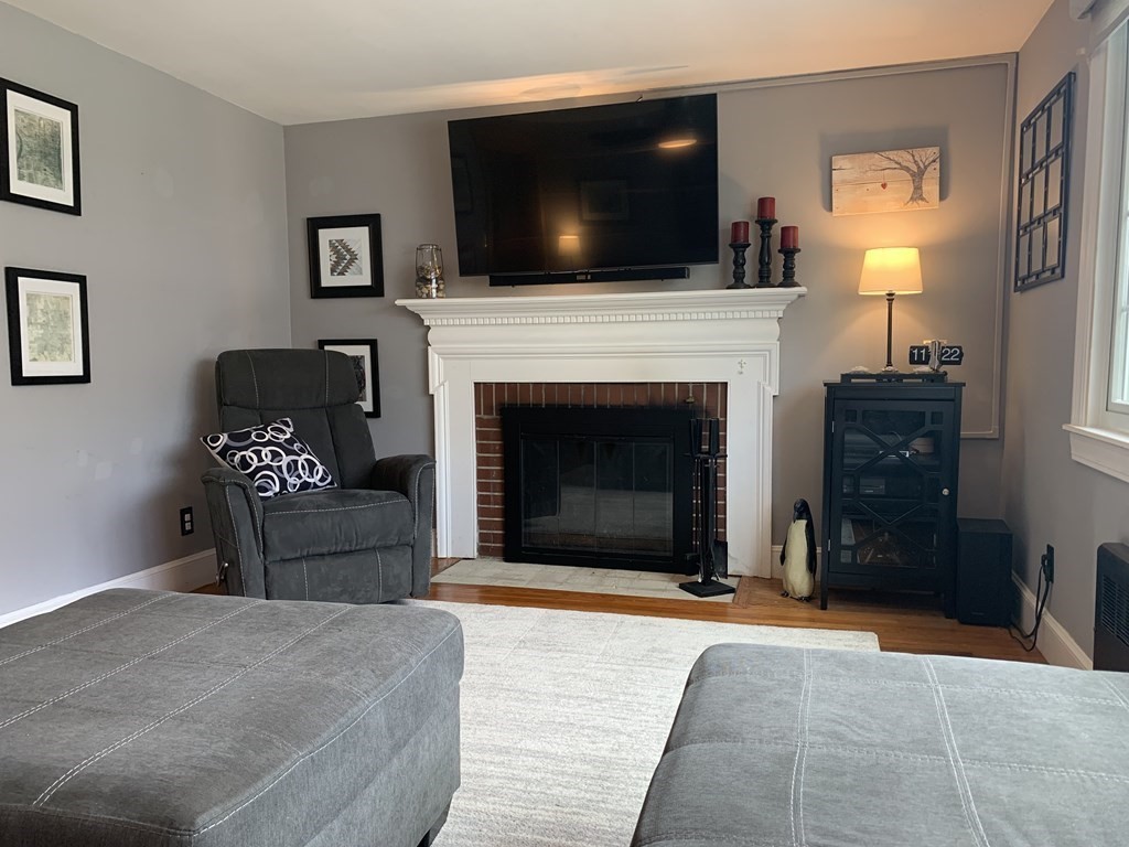 29 Bridge Street Hamilton, MA 01982 - Photo 4 of 16 a living room with furniture a flat screen tv and a fireplace
