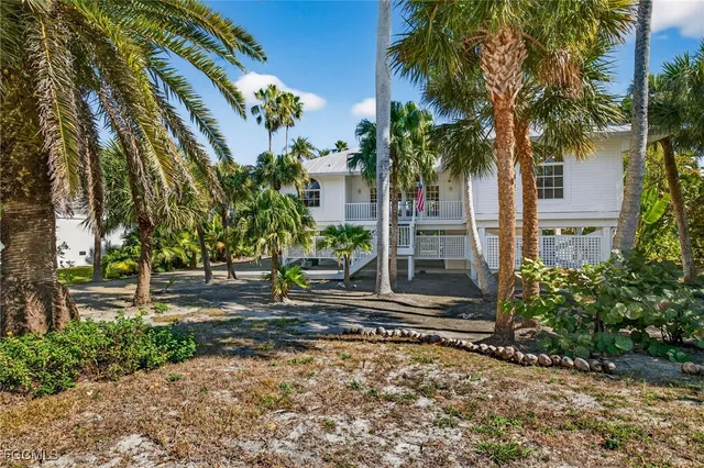 a front view of a house with a yard and potted plants