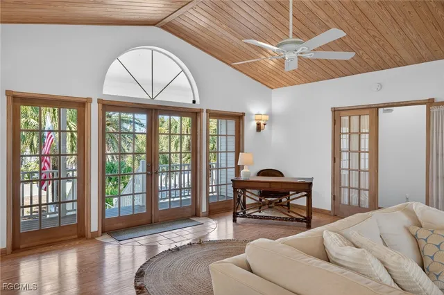 a bedroom with furniture large windows and a ceiling fan