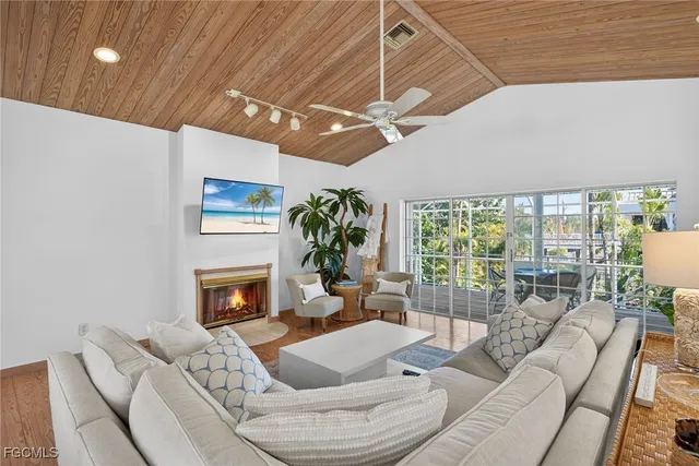 a living room with furniture a fireplace and a floor to ceiling window
