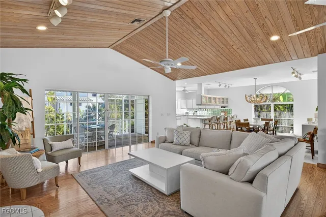 a living room with furniture kitchen view and a large window