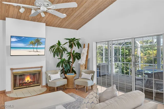 a living room with furniture a floor to ceiling window and potted plants