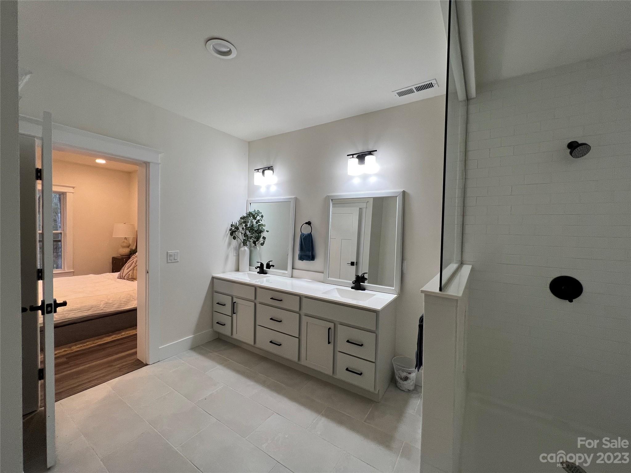 152 Cascade Rdg Road Fairview, NC 28730 - Photo 12 of 18 a bathroom with a double vanity sink a mirror and shower