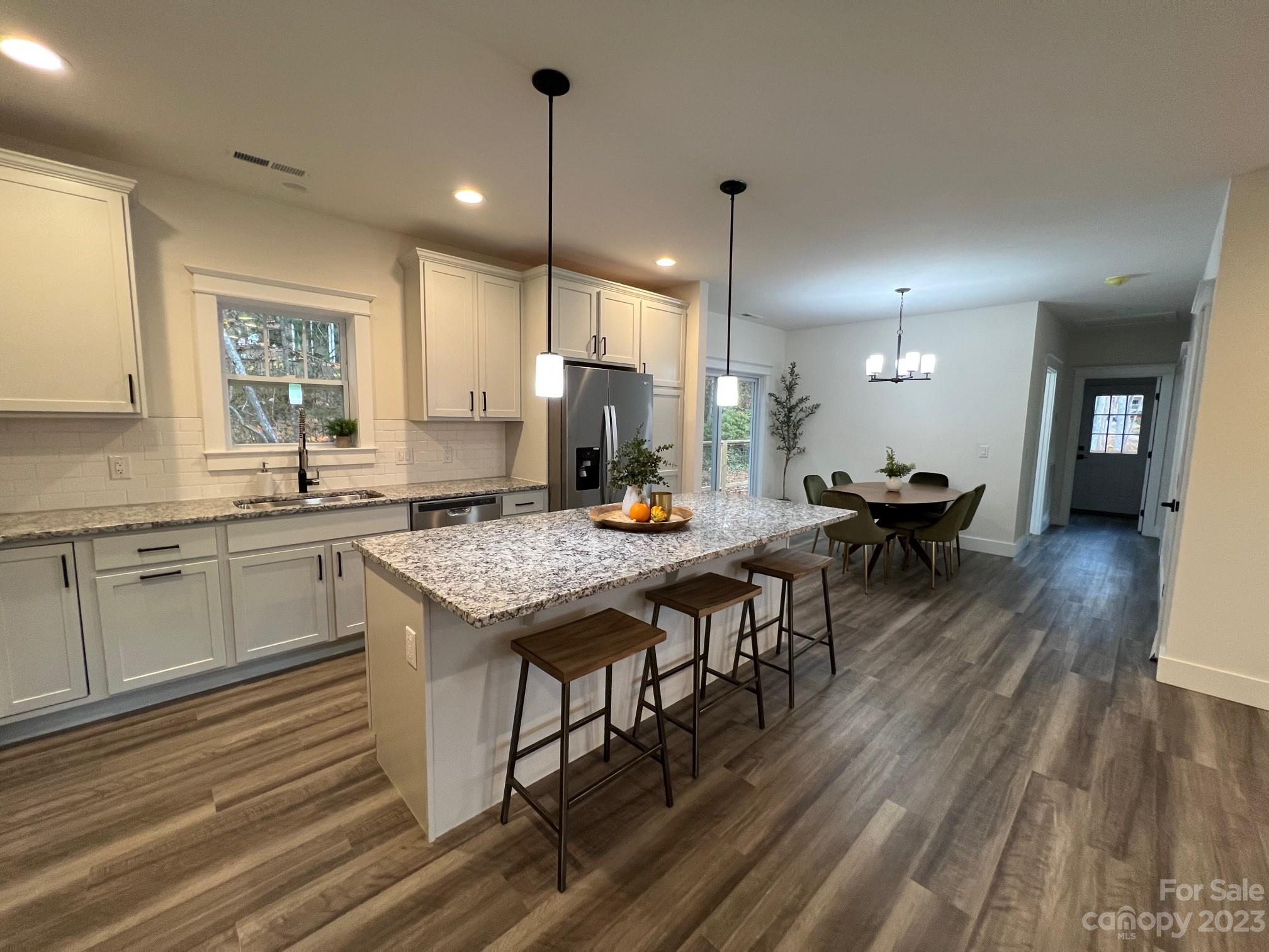 152 Cascade Rdg Road Fairview, NC 28730 - Photo 7 of 18 a kitchen with a table chairs sink and wooden floor