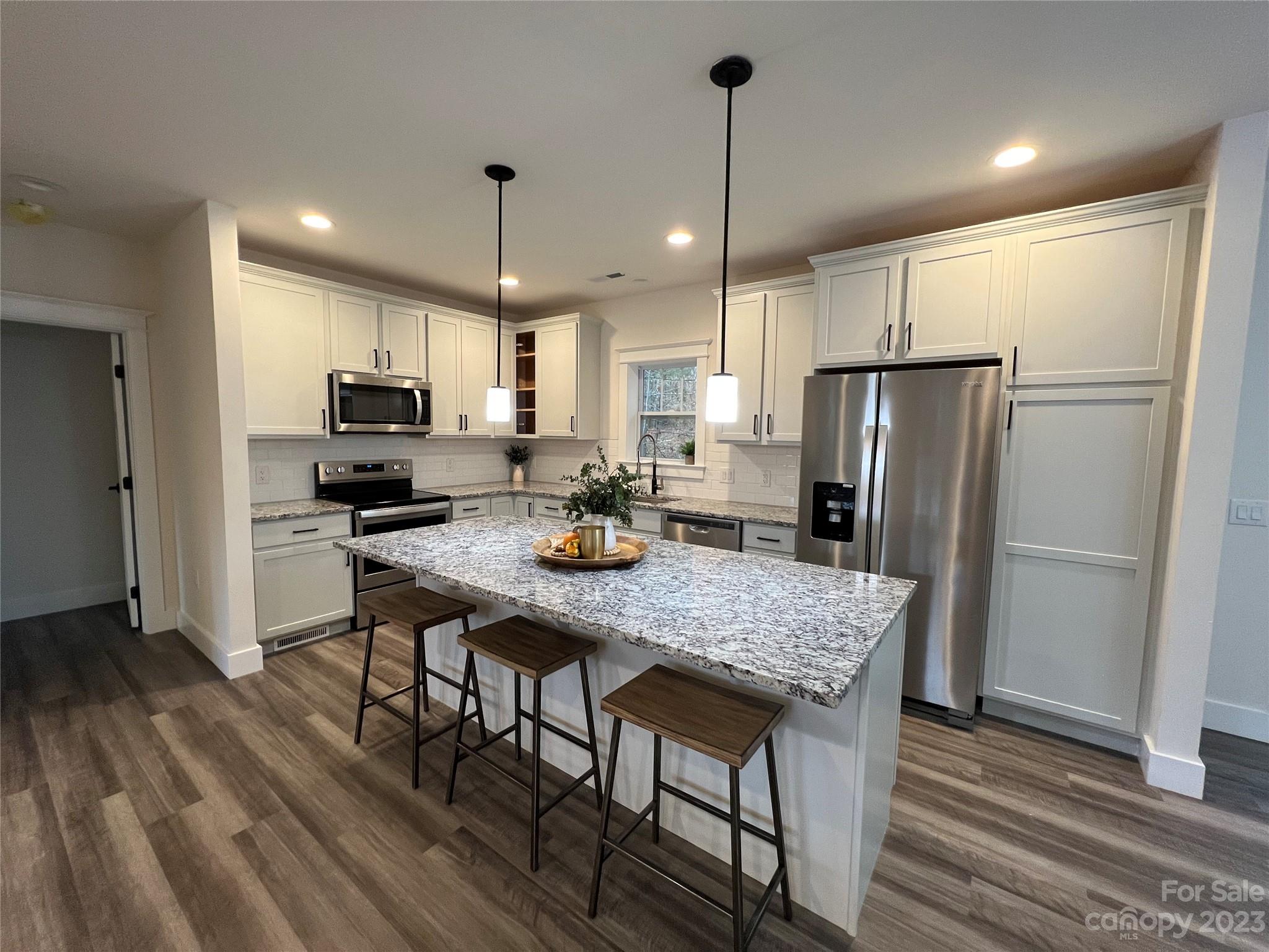 152 Cascade Rdg Road Fairview, NC 28730 - Photo 8 of 18 a kitchen with stainless steel appliances granite countertop a refrigerator a stove a microwave oven a sink with a dining table and chairs