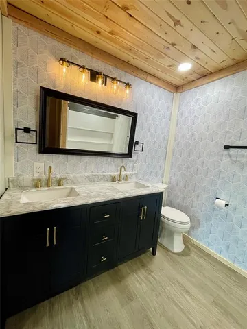 a bathroom with a toilet sink double vanity and mirror
