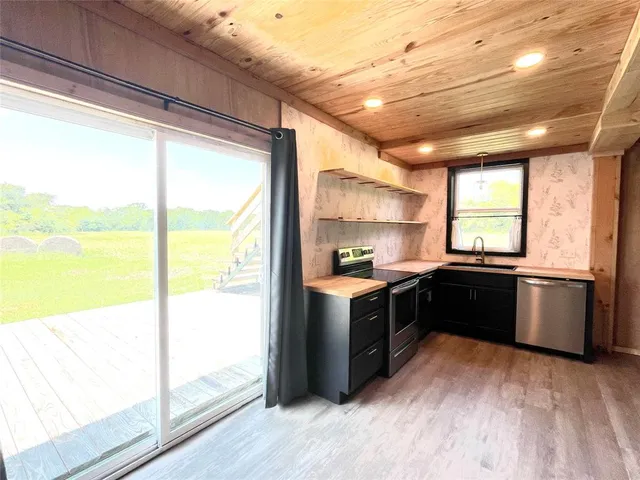 a kitchen with a large window and wooden floor