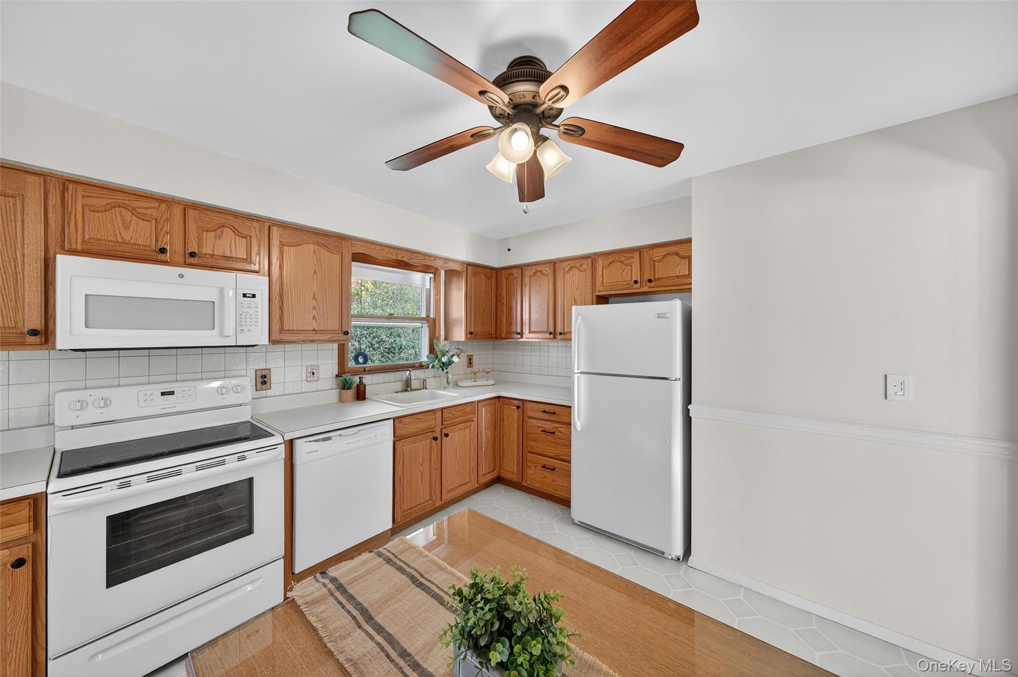 18 Rondack Road Middletown, NY 10941 - Photo 13 of 33 Kitchen featuring white appliances, decorative backsplash, light countertops, brown cabinets, and light tile patterned floors