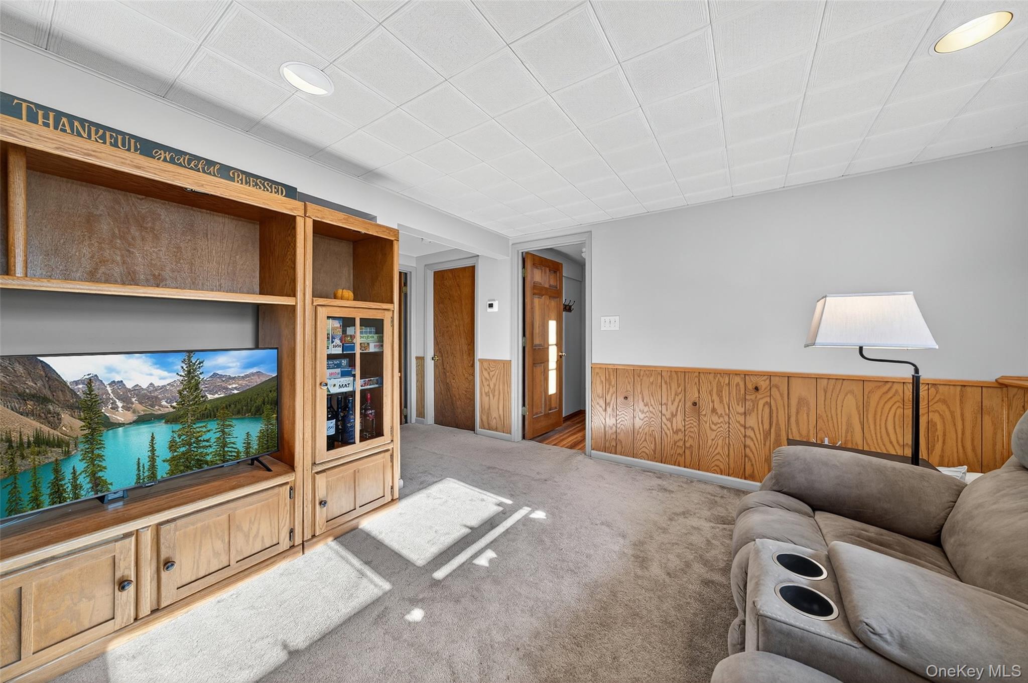 18 Rondack Road Middletown, NY 10941 - Photo 24 of 33 Carpeted living area featuring a wainscoted wall, wood walls, and a paneled ceiling