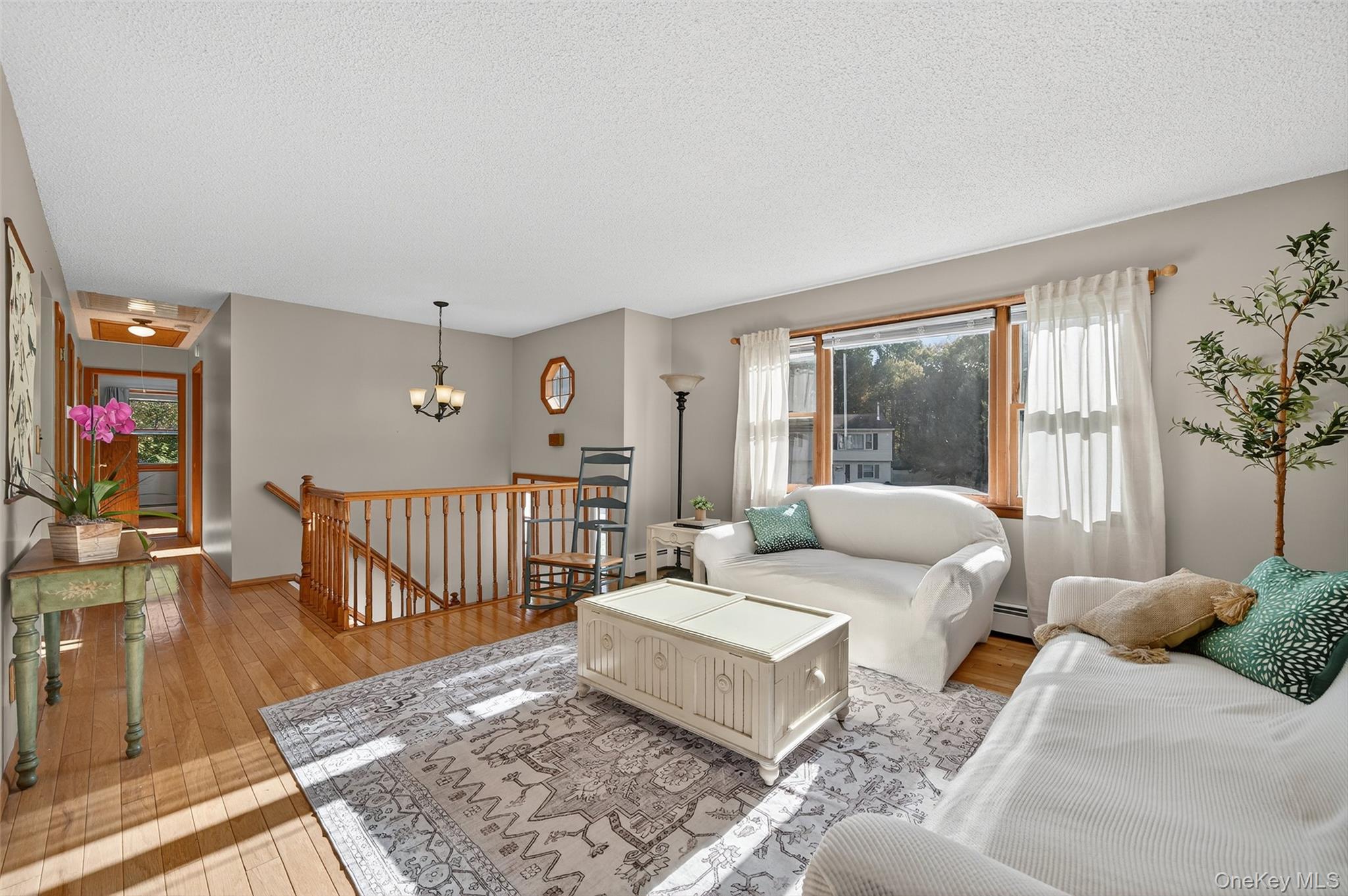18 Rondack Road Middletown, NY 10941 - Photo 7 of 33 Living room with light wood-type flooring, a textured ceiling, and a chandelier