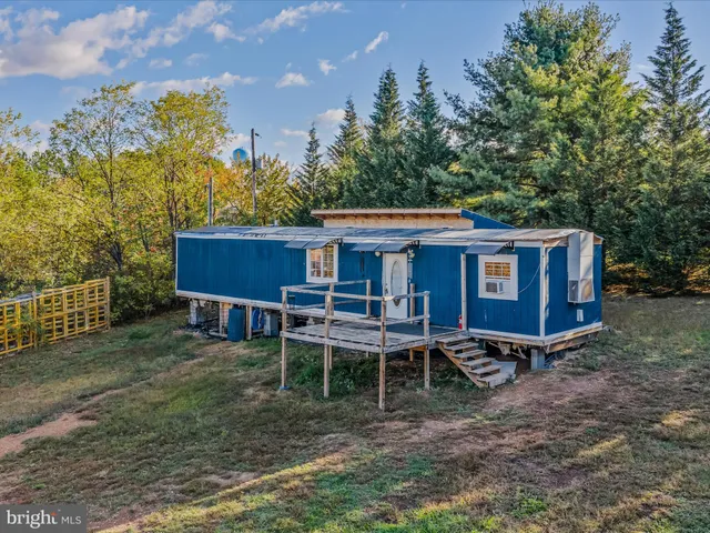 a view of a house with a yard and wooden fence