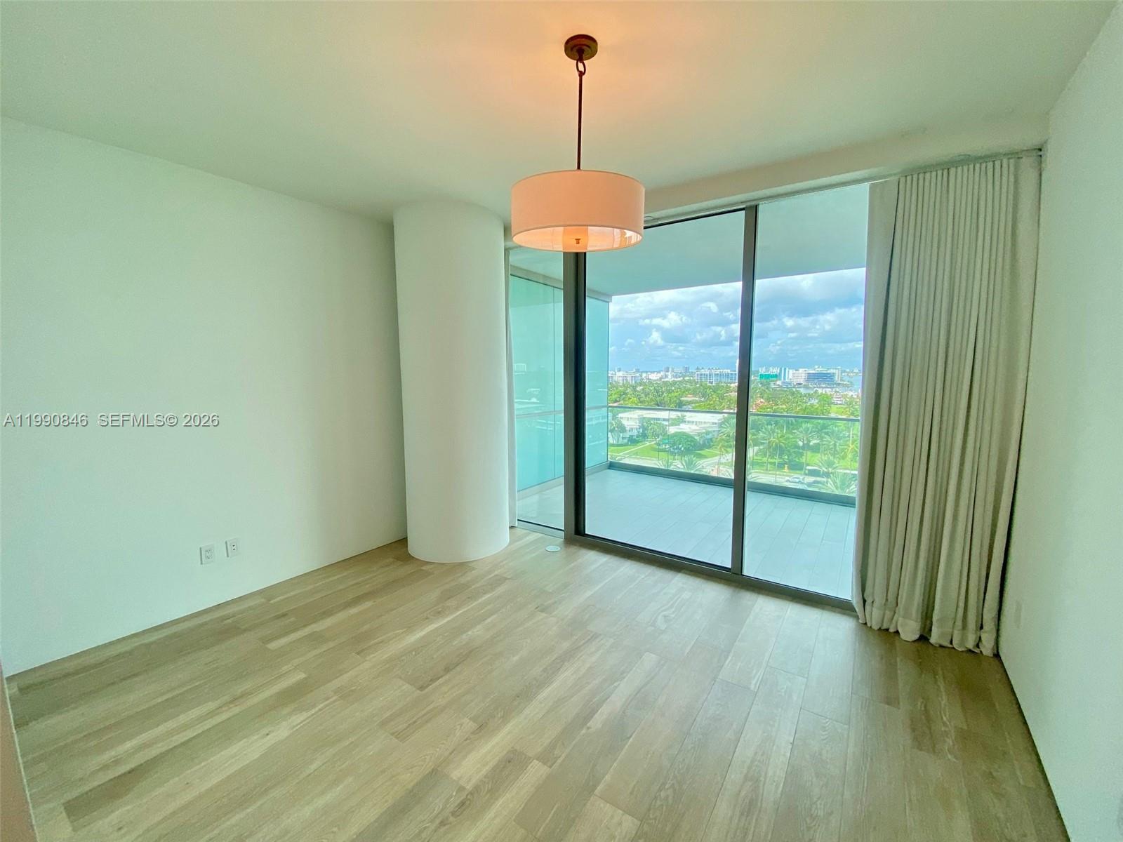10203 Collins Avenue, Unit 905 Bal Harbour, FL 33154 - Photo 16 of 35 a view of an empty room with chandelier and a window