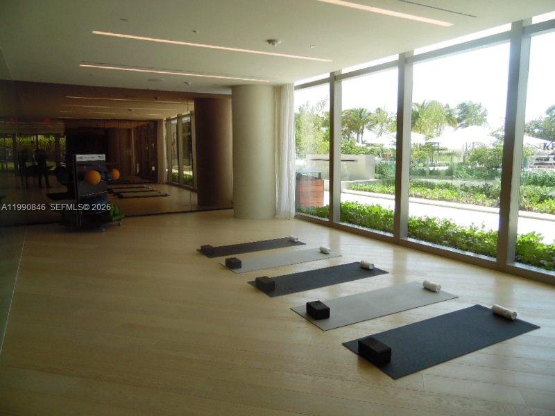 10203 Collins Avenue, Unit 905 Bal Harbour, FL 33154 - Photo 29 of 35 a room with gym equipment and large windows