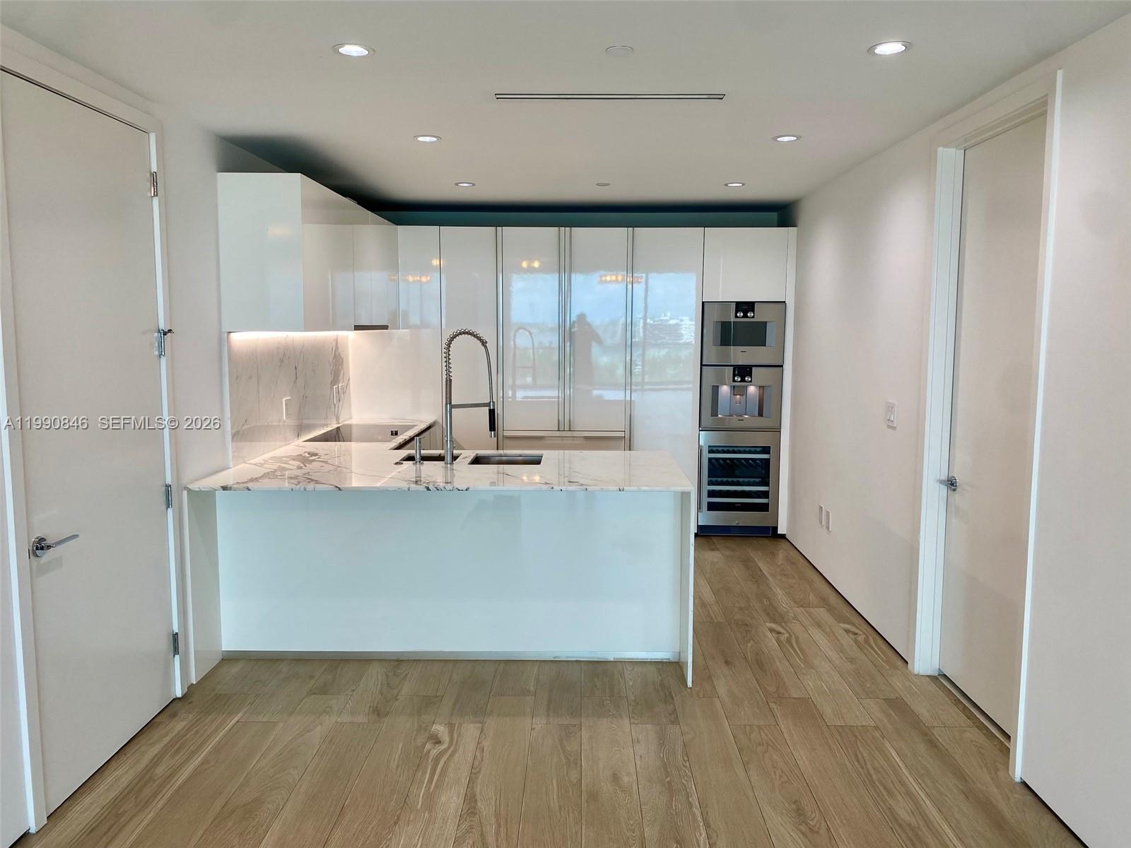 10203 Collins Avenue, Unit 905 Bal Harbour, FL 33154 - Photo 6 of 35 a view of kitchen with stainless steel appliances granite countertop a refrigerator a sink and a stove
