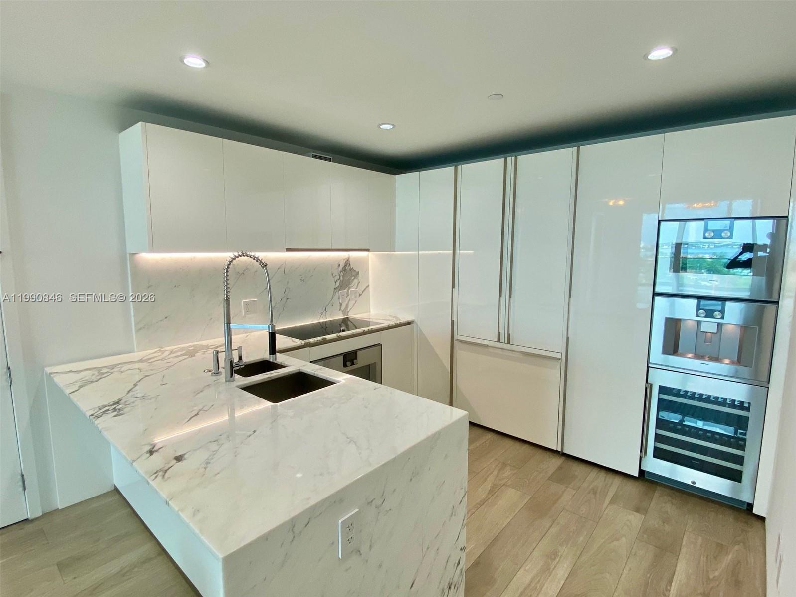 10203 Collins Avenue, Unit 905 Bal Harbour, FL 33154 - Photo 7 of 35 a kitchen with kitchen island a sink a stove and a refrigerator