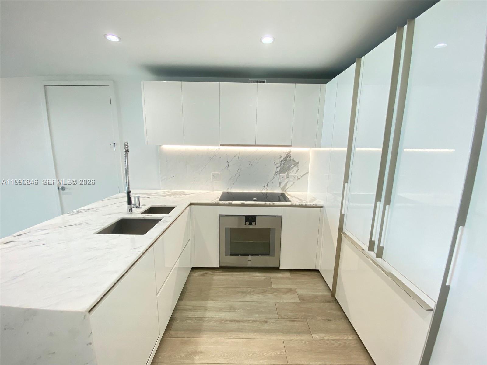 10203 Collins Avenue, Unit 905 Bal Harbour, FL 33154 - Photo 8 of 35 a kitchen with a sink stove and cabinets