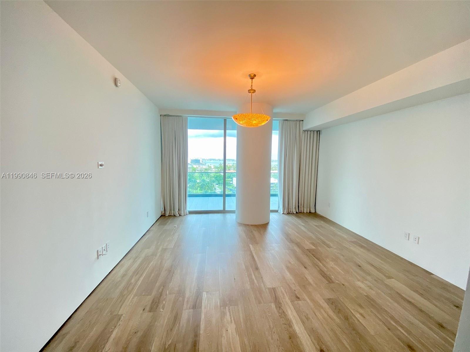 10203 Collins Avenue, Unit 905 Bal Harbour, FL 33154 - Photo 9 of 35 a view of a room with wooden floor and window