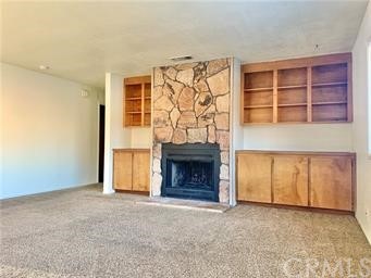 an empty room with a fireplace and cabinet