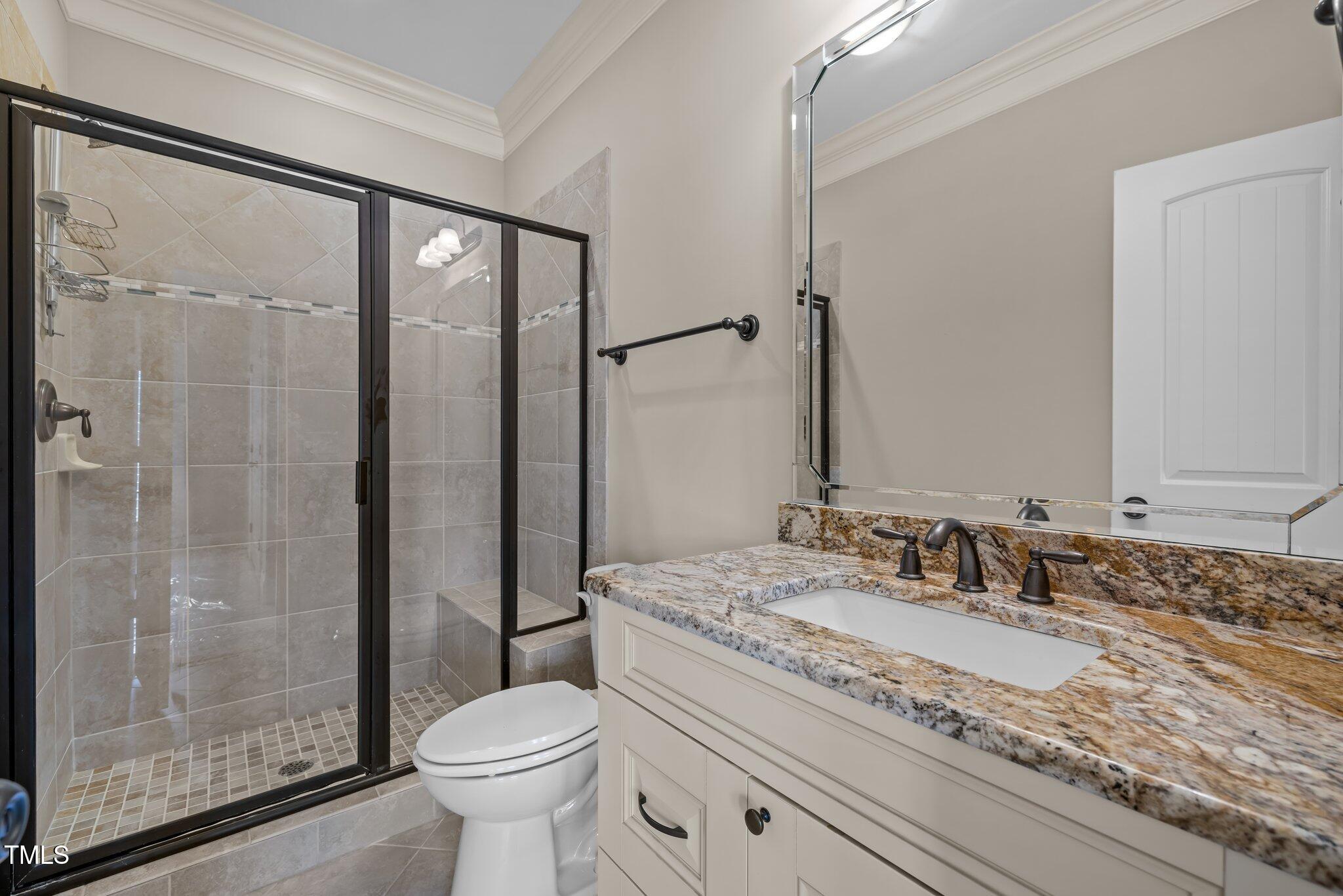 1086 Tender Drive Apex, NC 27502 - Photo 22 of 35 a bathroom with a granite countertop sink toilet and shower