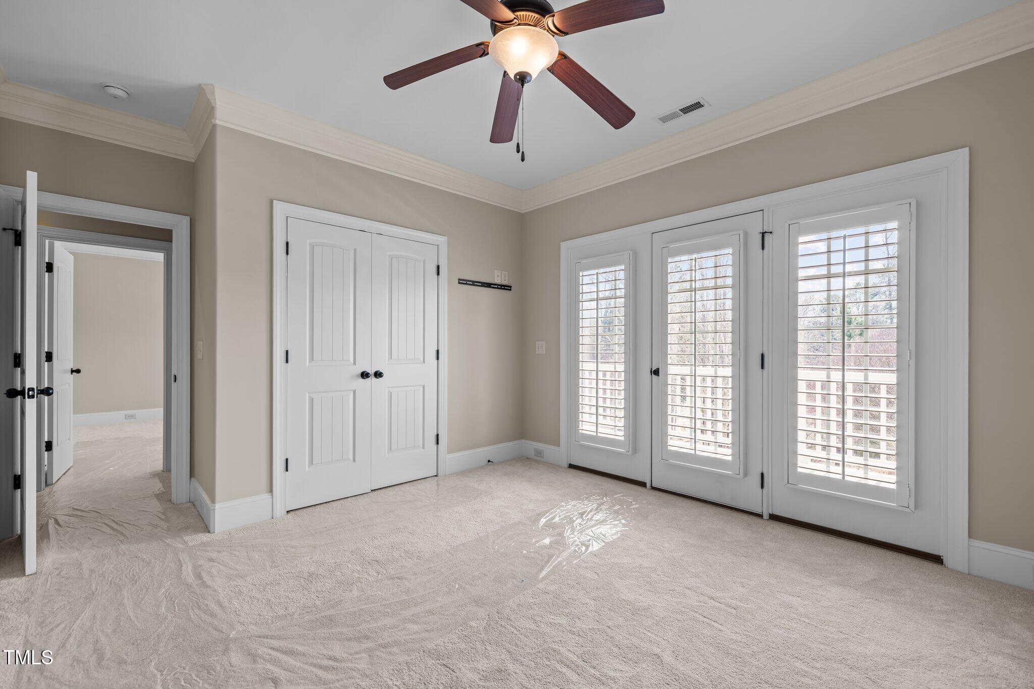 1086 Tender Drive Apex, NC 27502 - Photo 24 of 35 a view of an empty room with chandelier fan and windows