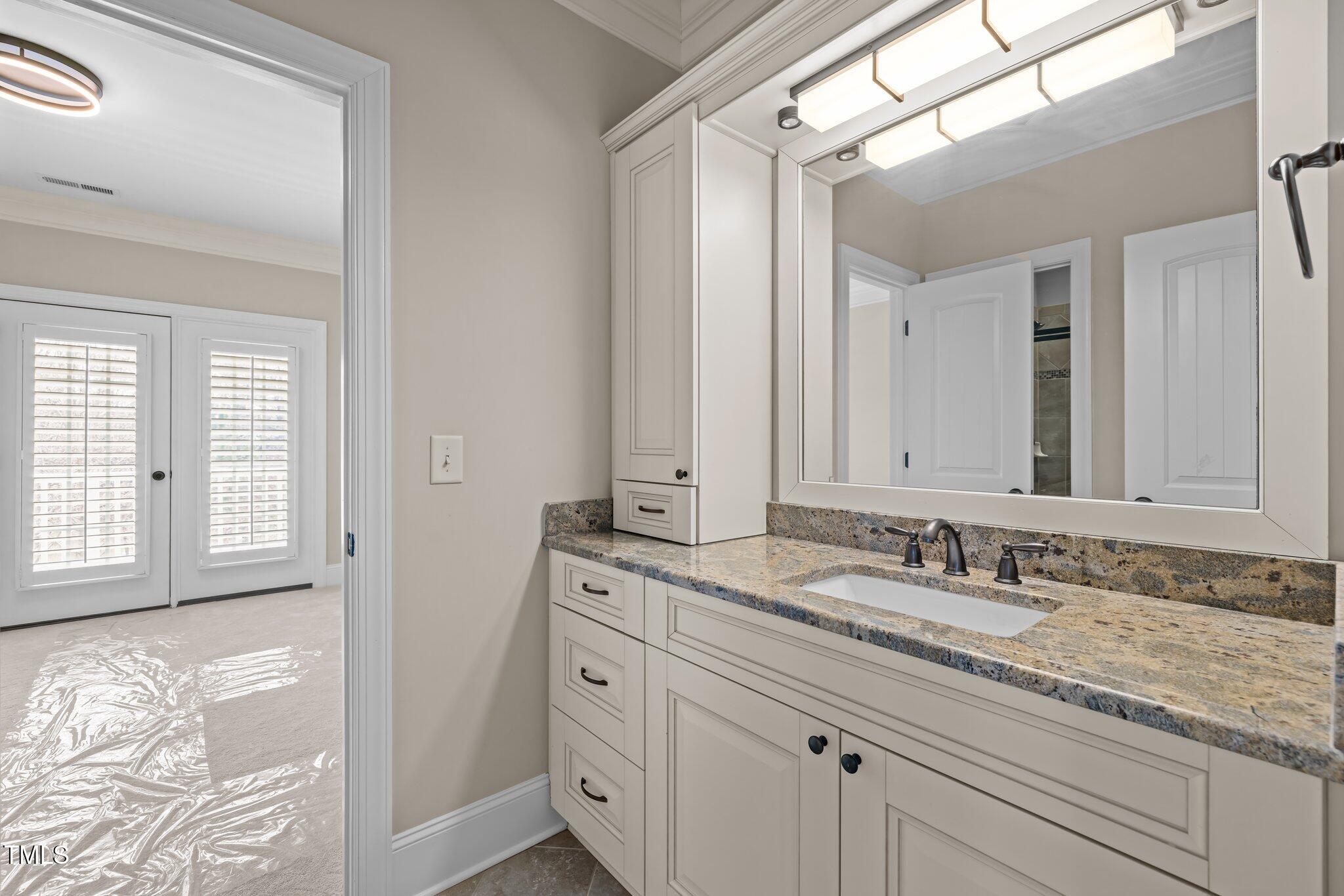 1086 Tender Drive Apex, NC 27502 - Photo 26 of 35 a bathroom with a granite countertop sink and a mirror