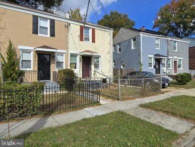 5420 B Street Southeast Washington, DC 20019 - Photo 3 of 3 a view of a white house with large windows and a small yard