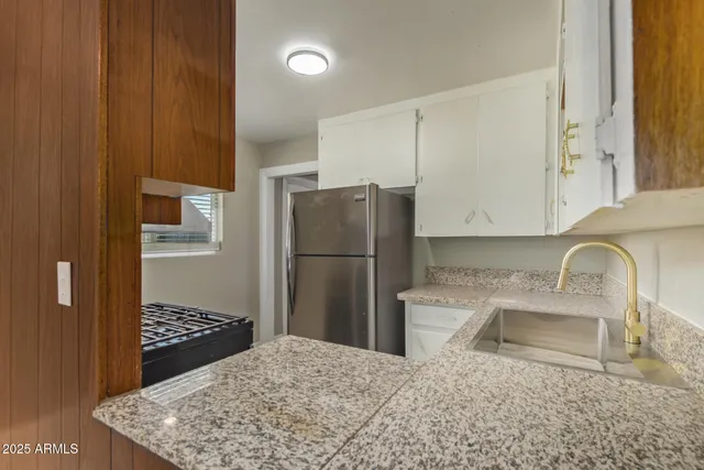 a kitchen with stainless steel appliances granite countertop a refrigerator and a sink