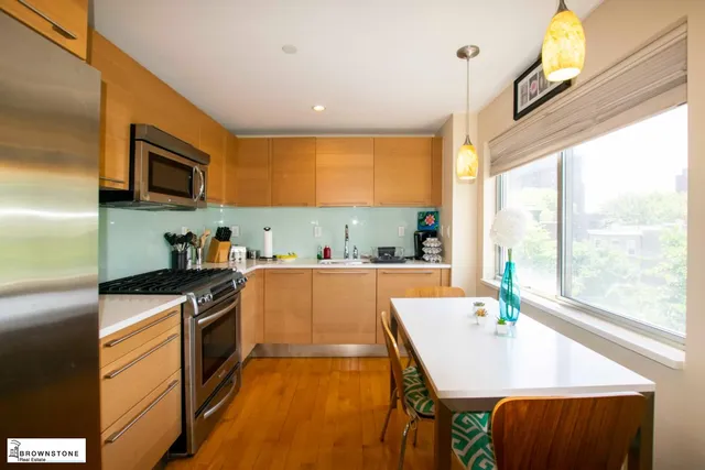 a kitchen with stainless steel appliances granite countertop a sink a stove and a refrigerator