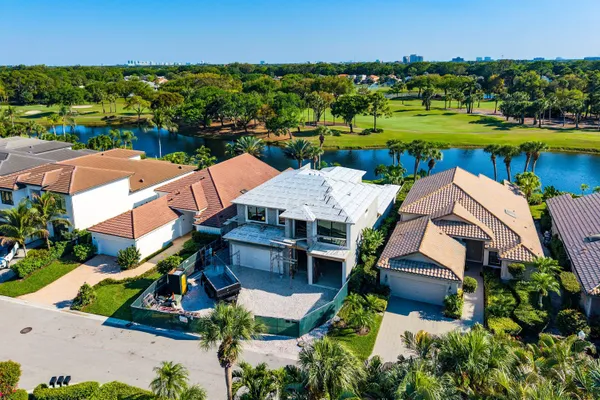 an aerial view of residential houses with outdoor space and lake view