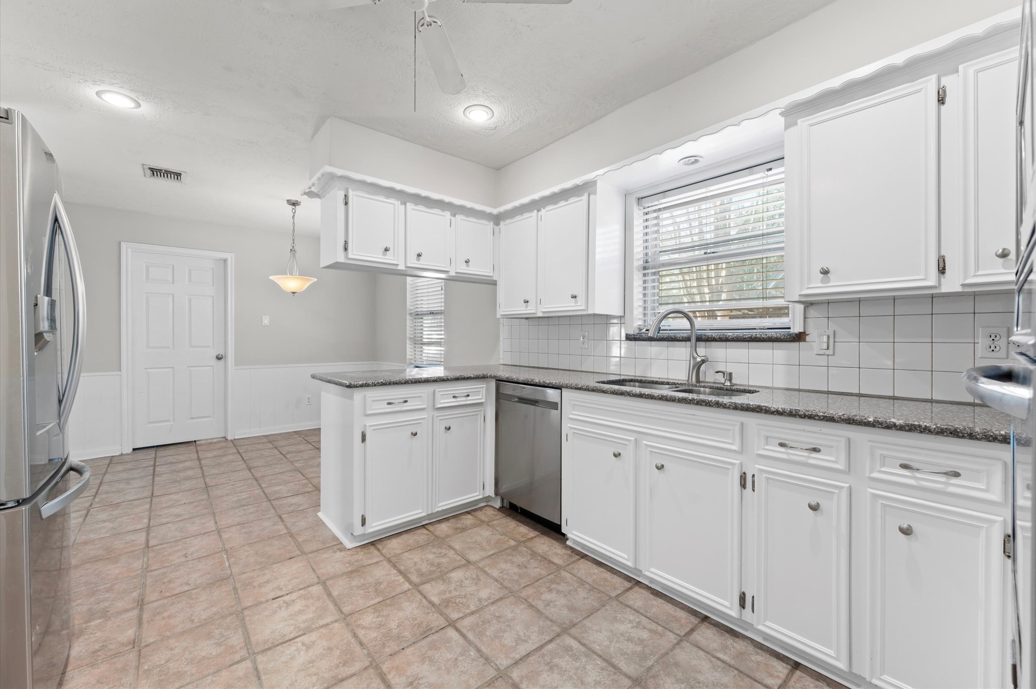 19415 Craigchester Lane Spring, TX 77388 - Photo 11 of 31 a kitchen with granite countertop white cabinets white appliances with a sink and a window