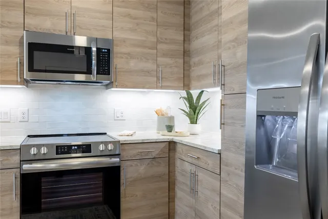 a kitchen with stainless steel appliances a stove a microwave and a sink