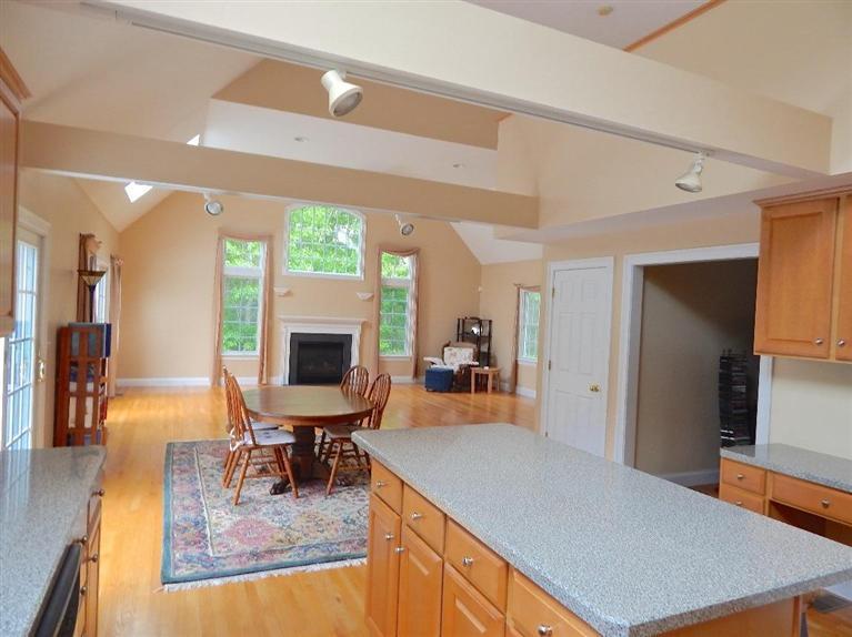 367 Service Road Sandwich, MA 02537 - Photo 16 of 34 a kitchen with stainless steel appliances granite countertop a stove top oven a sink dishwasher a dining table and chairs with wooden floor