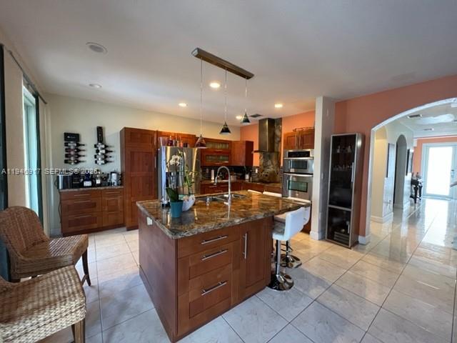 2530 Southwest 153rd Pass Miami, FL 33185 - Photo 5 of 8 a kitchen with stainless steel appliances kitchen island granite countertop a refrigerator a stove a sink and a dining table with the view