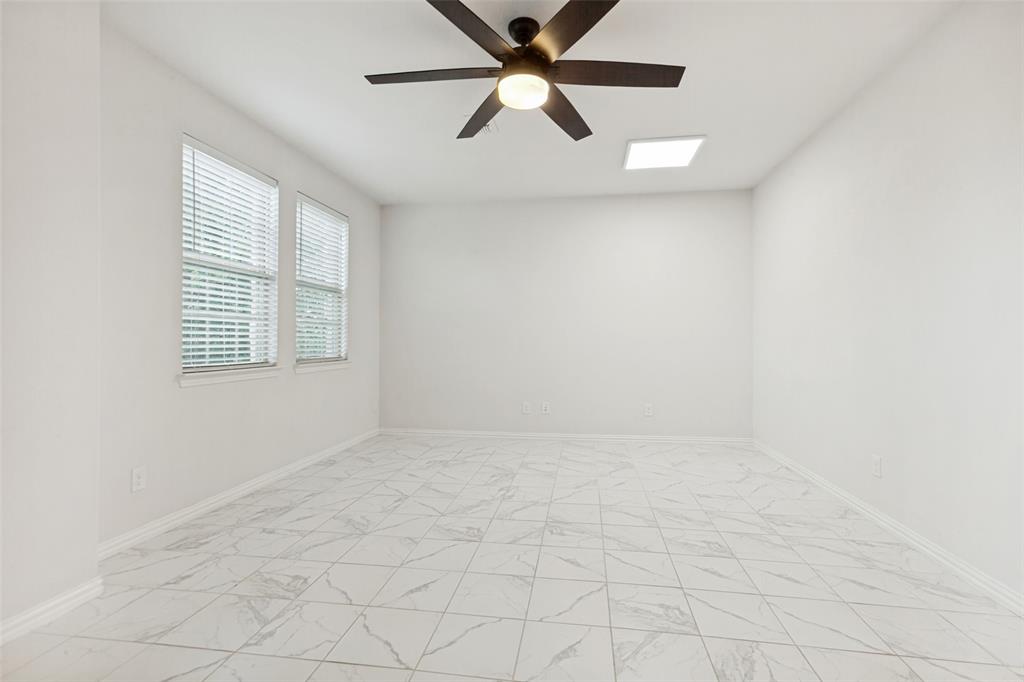 605 Ansley Way Allen, TX 75013 - Photo 17 of 28 Spacious room featuring white tile flooring with gray veining, dual windows with blinds, a ceiling fan with integrated lighting, and a recessed ceiling light fixture