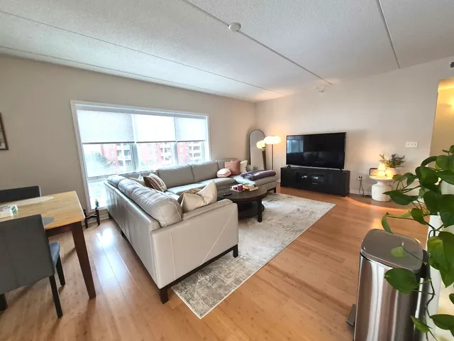 a living room with furniture flat screen tv and window