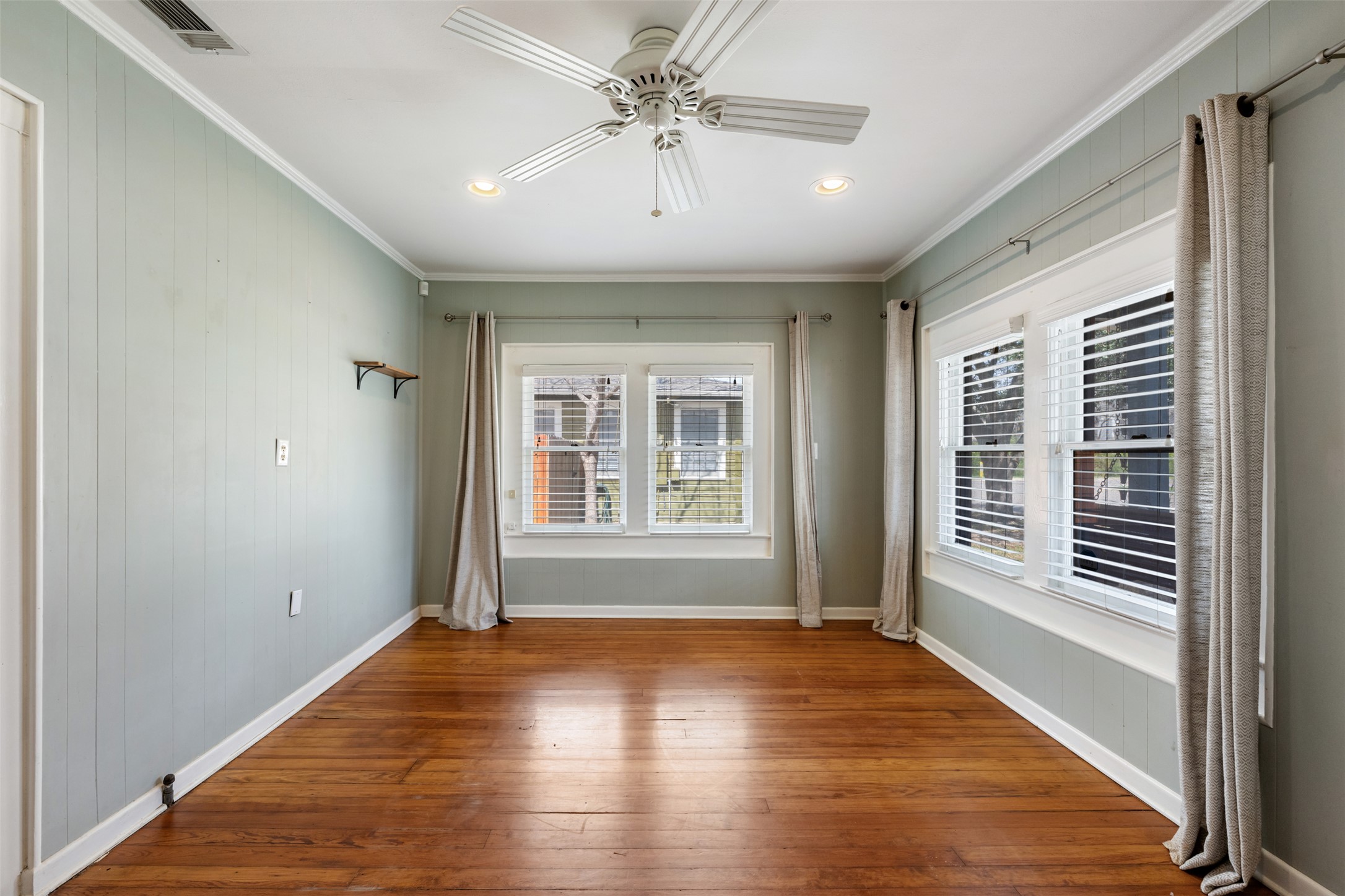 1218 South Myrtle Street Georgetown, TX 78626 - Photo 11 of 37 Living room with wood walls, a ceiling fan, dark wood-style floors, crown molding, and recessed lighting