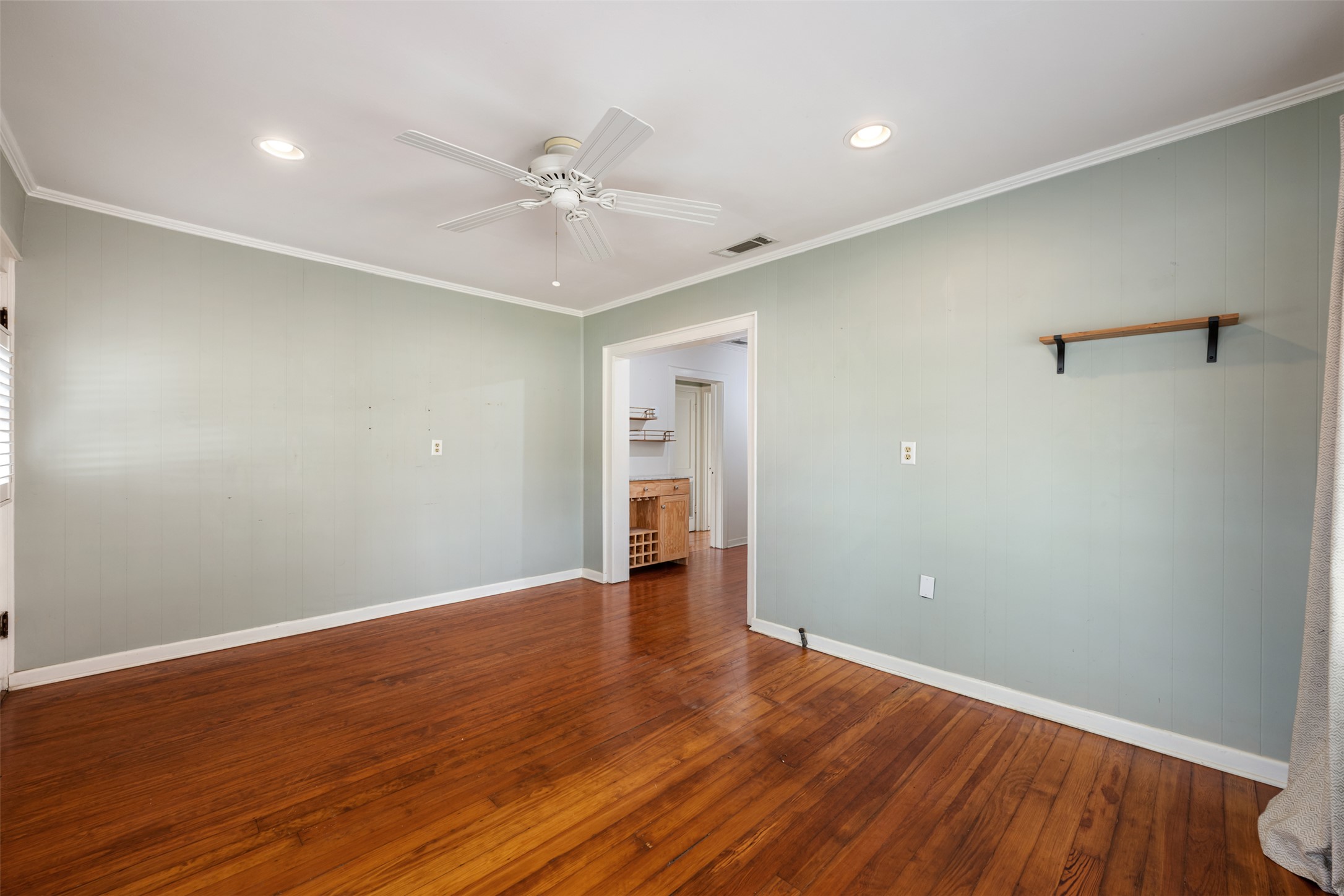 1218 South Myrtle Street Georgetown, TX 78626 - Photo 12 of 37 Living room with wood walls, ceiling fan, dark wood-type flooring, recessed lighting, and ornamental molding