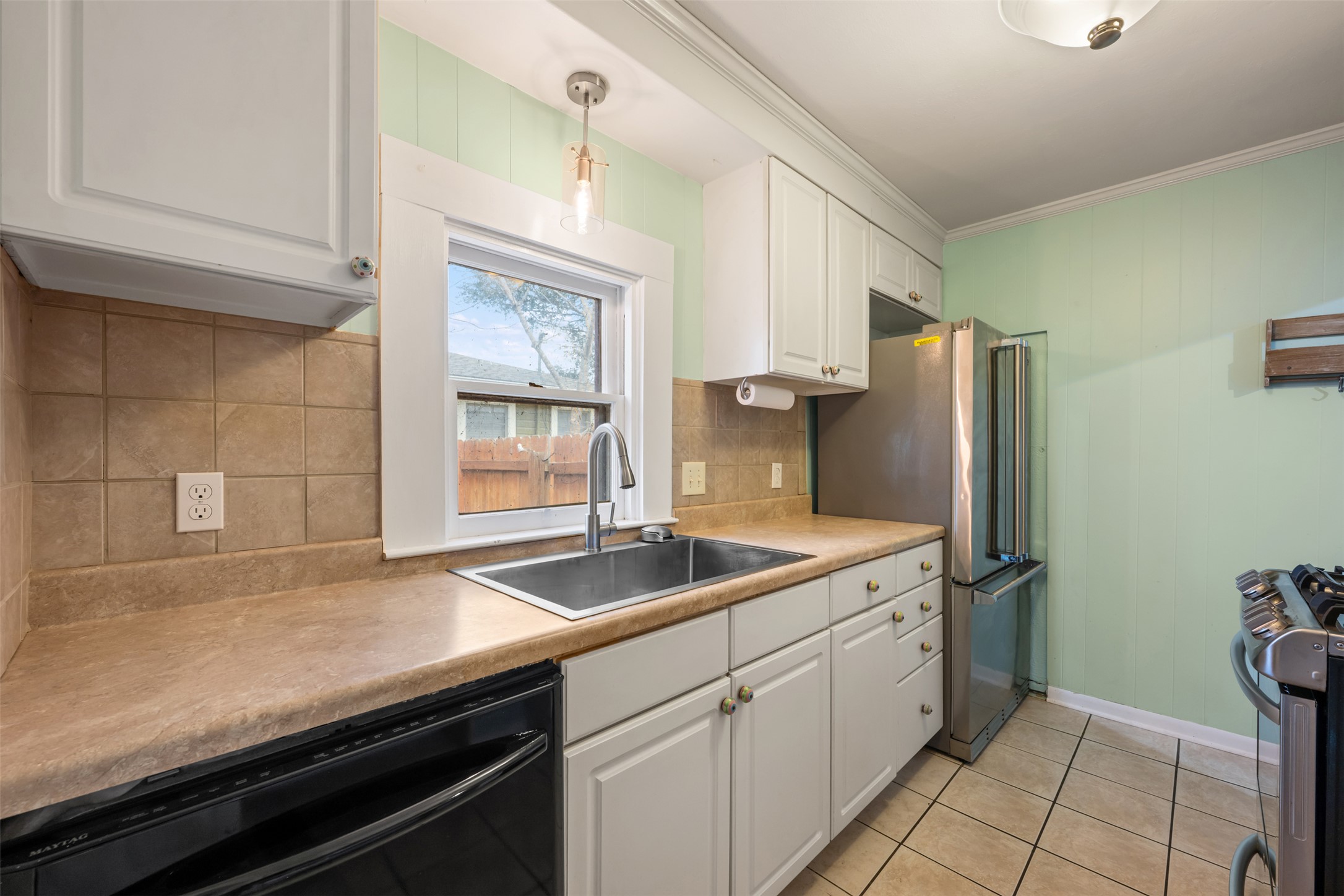 1218 South Myrtle Street Georgetown, TX 78626 - Photo 20 of 37 Kitchen featuring white cabinets, stainless steel appliances, crown molding, light countertops, and tasteful backsplash