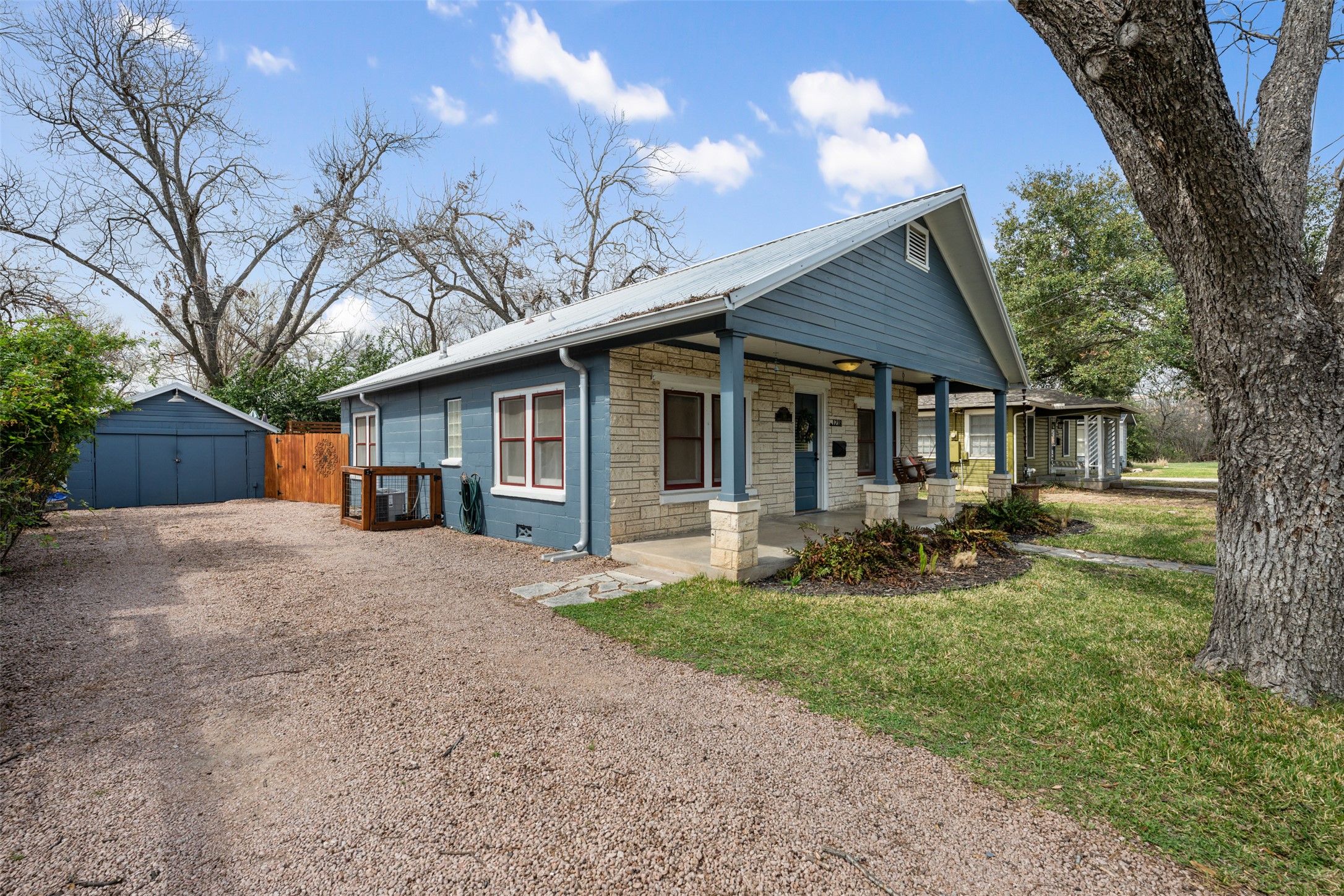 1218 South Myrtle Street Georgetown, TX 78626 - Photo 3 of 37 View of front facade featuring covered porch, gravel driveway, a shed, and stone siding