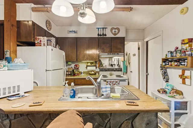 a kitchen with stainless steel appliances kitchen island granite countertop a dining table and chairs