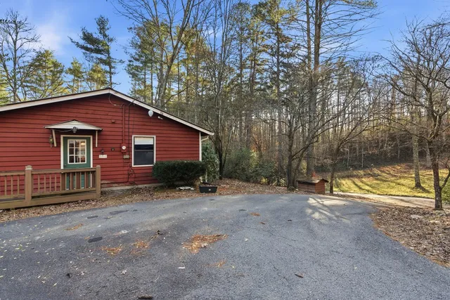 a view of a house with a yard and large tree
