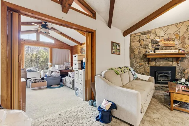 a living room with furniture a fireplace and a floor to ceiling window